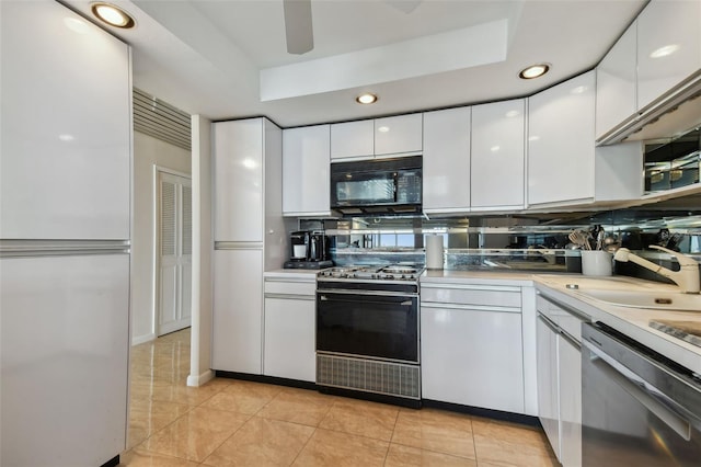 kitchen featuring dishwasher, backsplash, range, and white cabinetry