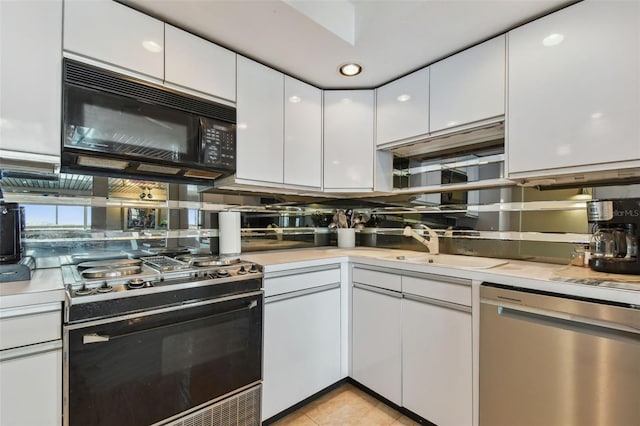 kitchen featuring white cabinets, light tile patterned flooring, range with gas cooktop, and stainless steel dishwasher