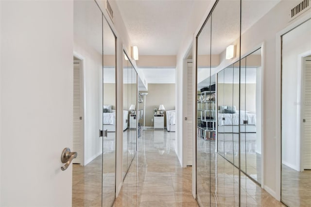 hall featuring a textured ceiling