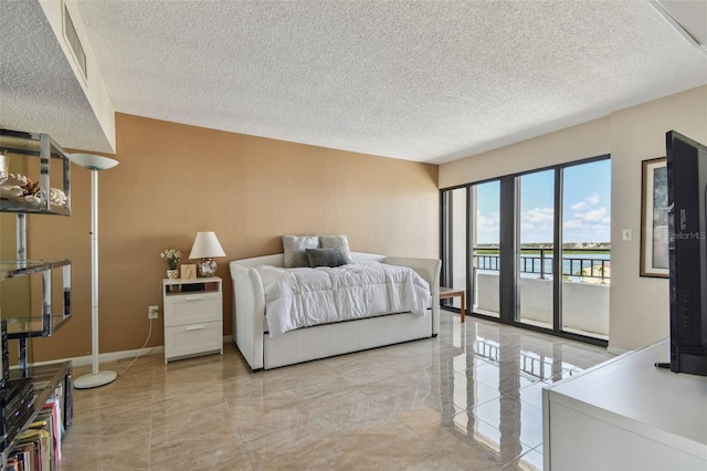 bedroom featuring access to outside and a textured ceiling