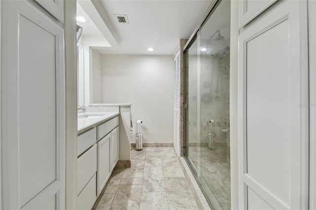 bathroom featuring a shower with shower door, vanity, and toilet