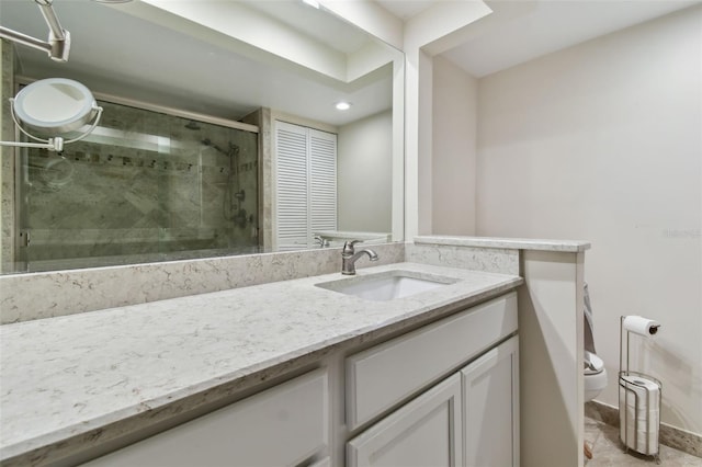 bathroom with walk in shower, vanity, and toilet