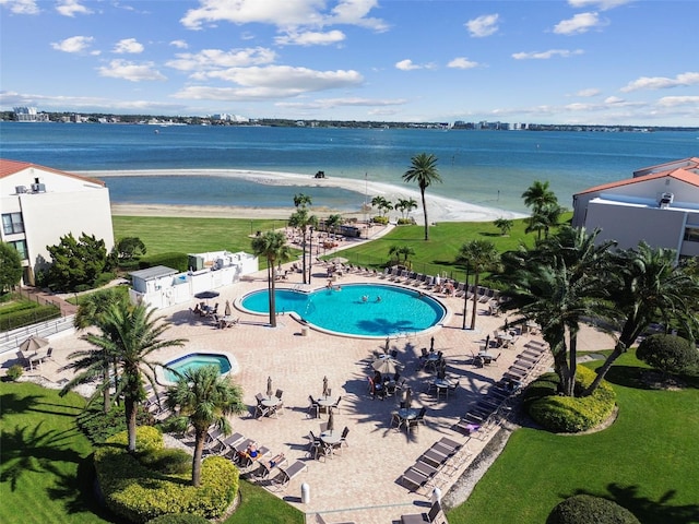 view of pool with a view of the beach, a lawn, a water view, and a patio area