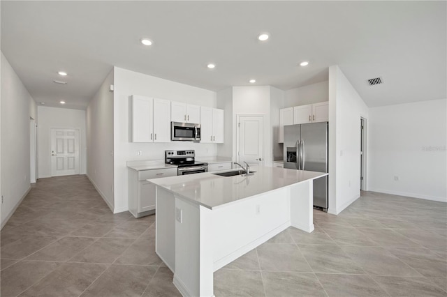 kitchen with white cabinets, an island with sink, stainless steel appliances, and sink