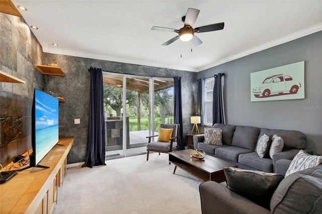 living room featuring carpet floors, a textured ceiling, ornamental molding, and ceiling fan