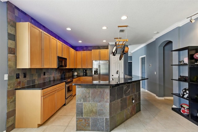 kitchen featuring decorative backsplash, an island with sink, light tile patterned floors, stainless steel appliances, and ornamental molding