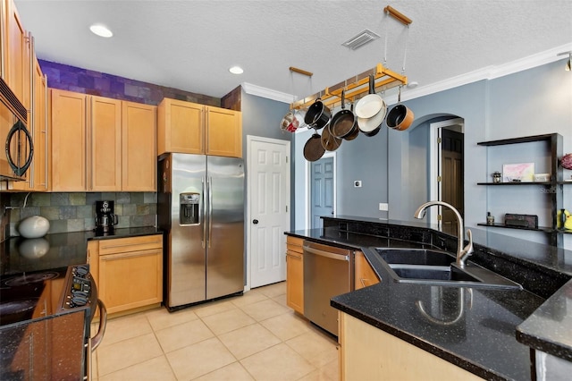 kitchen featuring dark stone countertops, light tile patterned floors, black appliances, light brown cabinetry, and sink