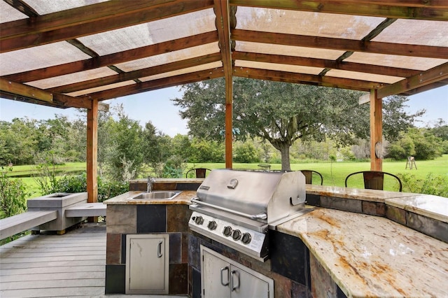 exterior space featuring area for grilling, sink, a deck, and a pergola