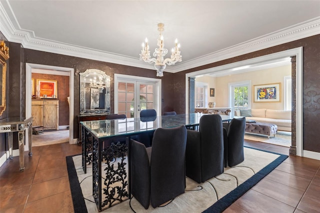 dining room featuring dark tile patterned floors, an inviting chandelier, french doors, and crown molding