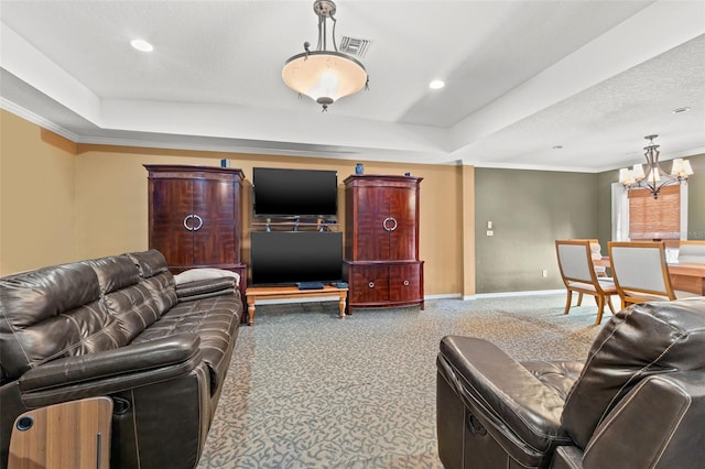 living room with a raised ceiling, ornamental molding, a textured ceiling, a chandelier, and carpet floors