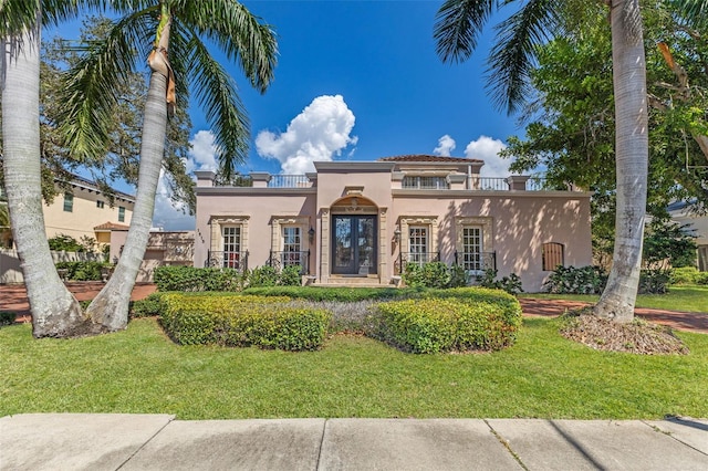 mediterranean / spanish house with a balcony and a front lawn