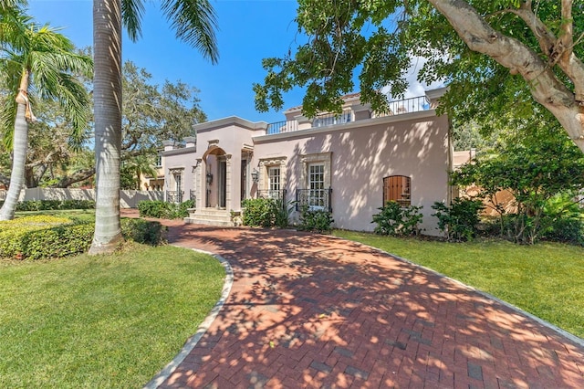 mediterranean / spanish home with a front yard and covered porch