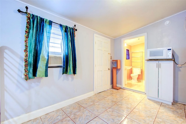 interior space featuring lofted ceiling and light tile patterned floors