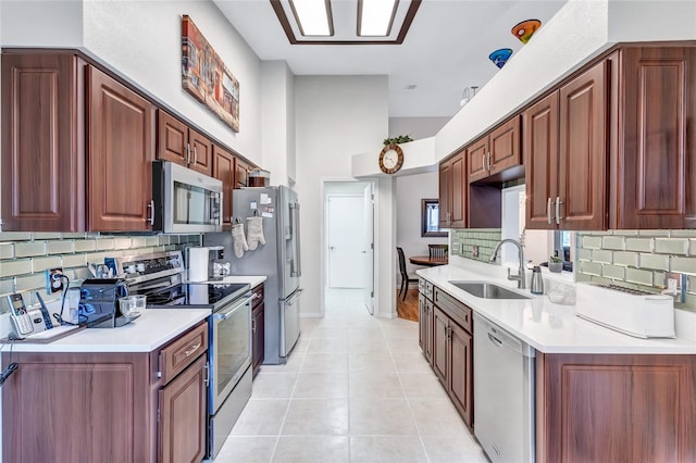 kitchen with light tile patterned flooring, stainless steel appliances, sink, and decorative backsplash