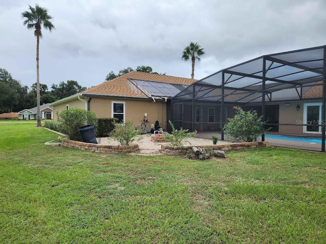 rear view of property with a lawn and a lanai