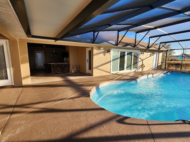 view of swimming pool featuring a patio area and a lanai