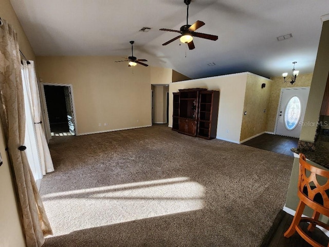 unfurnished living room featuring lofted ceiling, dark carpet, and ceiling fan with notable chandelier