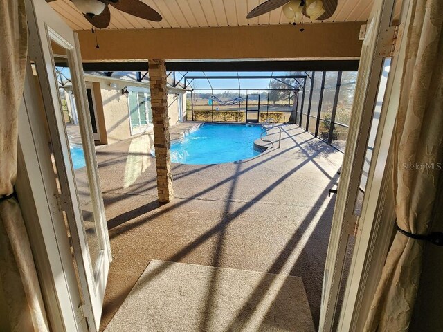 view of swimming pool featuring ceiling fan and a patio area