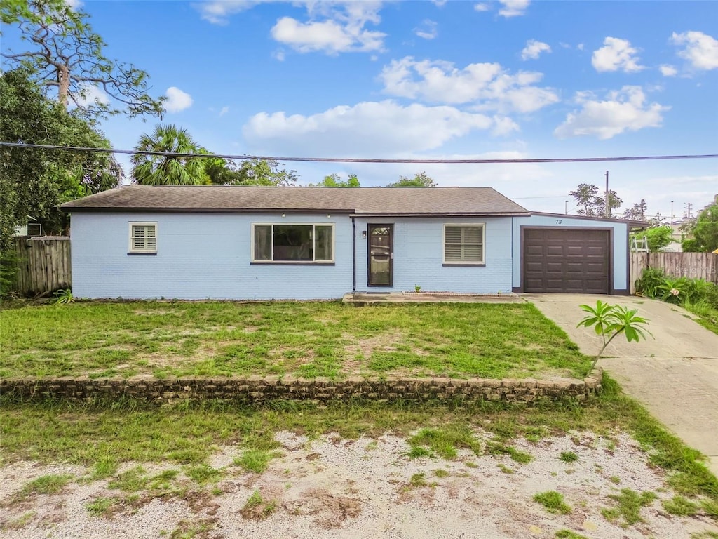 single story home with a front yard and a garage