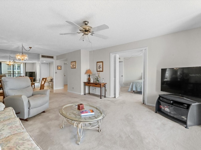 living room with a textured ceiling, light colored carpet, ceiling fan with notable chandelier, visible vents, and baseboards