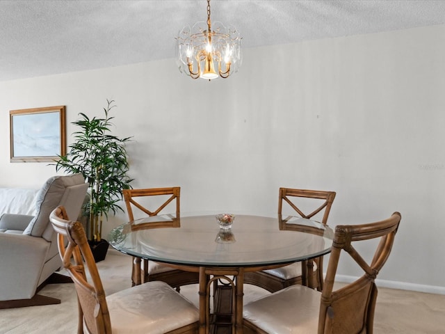 dining area featuring light colored carpet, a textured ceiling, baseboards, and an inviting chandelier