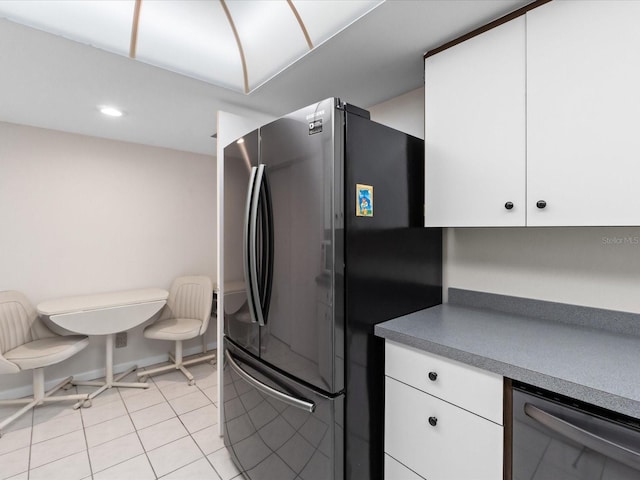 kitchen featuring recessed lighting, freestanding refrigerator, white cabinets, light tile patterned flooring, and dishwasher