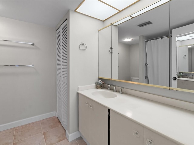 bathroom featuring a closet, visible vents, vanity, tile patterned flooring, and baseboards