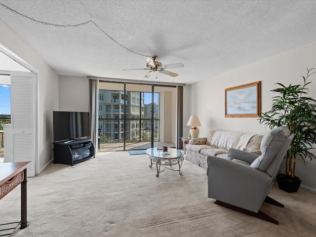 living room with expansive windows, baseboards, a textured ceiling, and light colored carpet