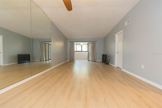 unfurnished living room with light wood-type flooring, vaulted ceiling, ceiling fan, and a textured ceiling