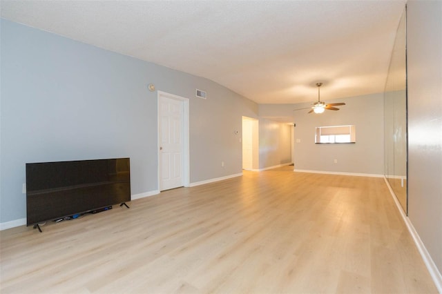 living room featuring light wood-type flooring, lofted ceiling, ceiling fan, and a textured ceiling