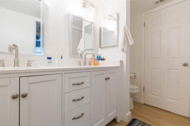 bathroom featuring vanity, hardwood / wood-style floors, and toilet