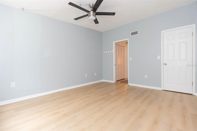 unfurnished room with ceiling fan, a textured ceiling, and light wood-type flooring