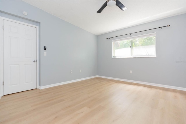 unfurnished room featuring a ceiling fan, light wood-type flooring, baseboards, and vaulted ceiling