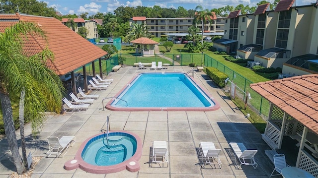 view of pool featuring a yard, a hot tub, and a patio area