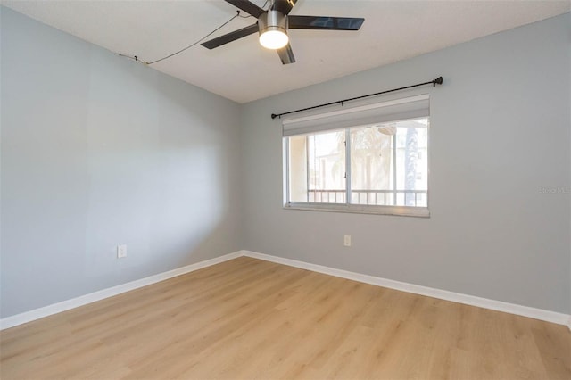 unfurnished room with baseboards, wood finished floors, and ceiling fan