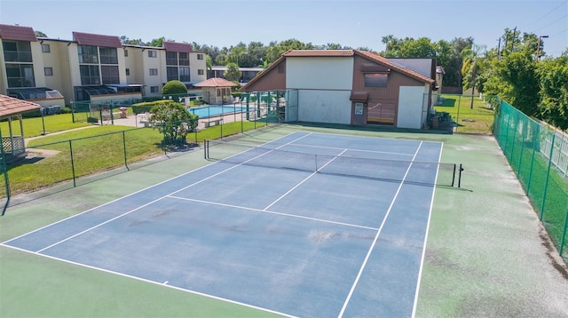 view of tennis court featuring fence