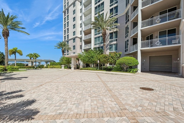 view of building exterior with a garage and decorative driveway