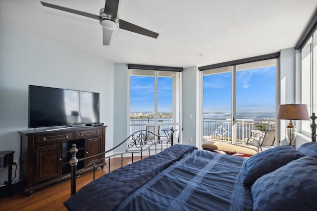 bedroom with a wall of windows, access to outside, ceiling fan, and dark wood-type flooring