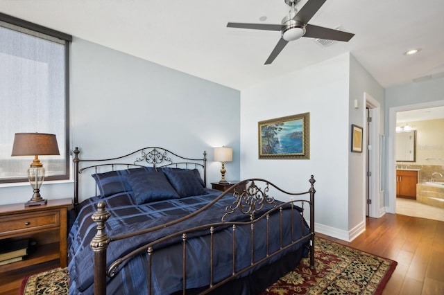 bedroom with ceiling fan, ensuite bath, and wood-type flooring