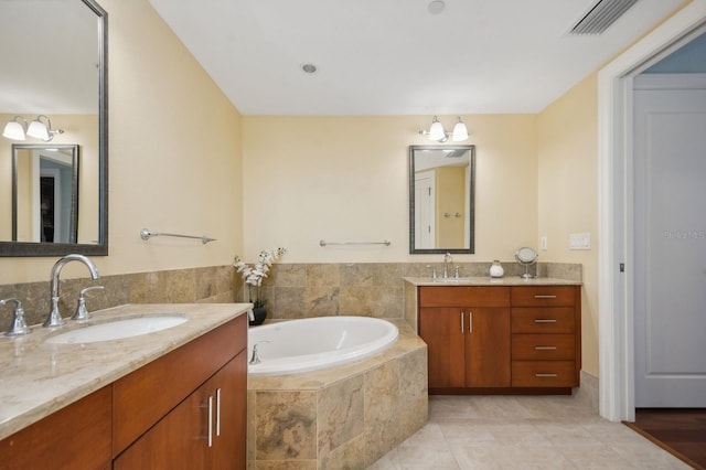 bathroom with vanity, tiled bath, and tile patterned floors