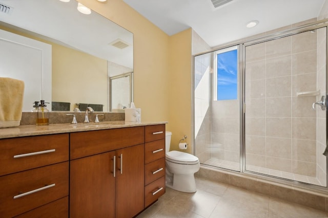 bathroom featuring tile patterned flooring, walk in shower, vanity, and toilet