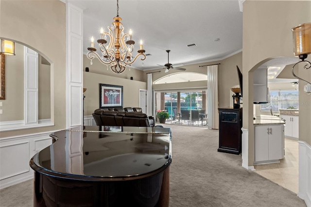 interior space with ceiling fan with notable chandelier and ornamental molding