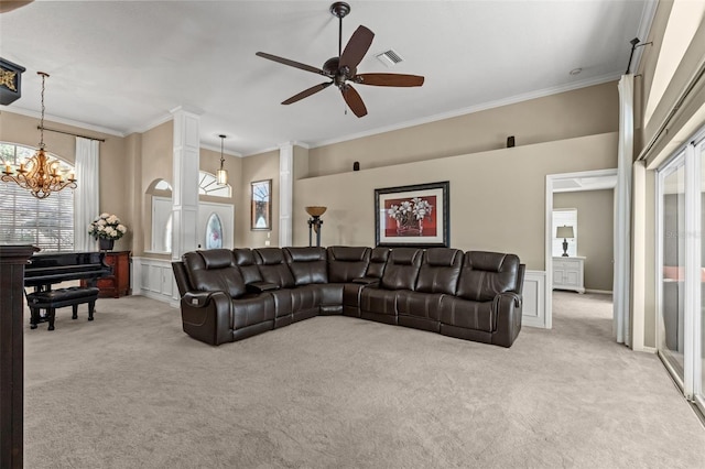 living room with ceiling fan with notable chandelier, ornate columns, light colored carpet, and crown molding