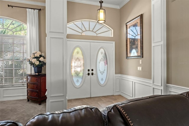 carpeted entrance foyer with french doors and ornamental molding