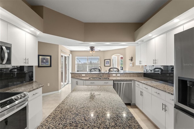 kitchen featuring sink, white cabinetry, kitchen peninsula, appliances with stainless steel finishes, and ceiling fan