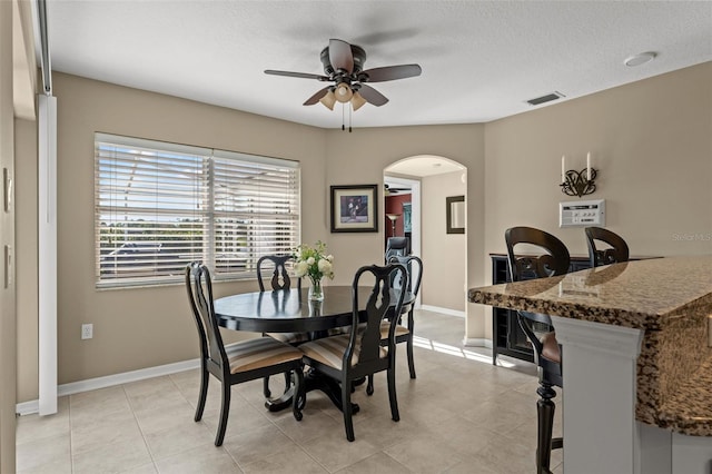 tiled dining space featuring a textured ceiling and ceiling fan