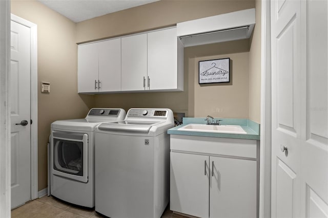 washroom featuring light tile patterned flooring, sink, independent washer and dryer, and cabinets