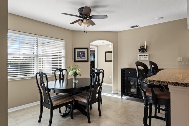 dining space with ceiling fan, light tile patterned floors, and a textured ceiling