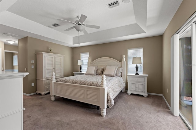 bedroom featuring multiple windows, a raised ceiling, ceiling fan, and carpet floors