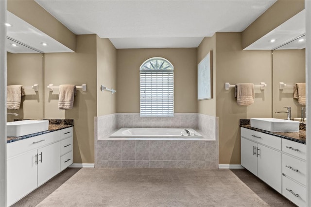 bathroom with vanity and a relaxing tiled tub